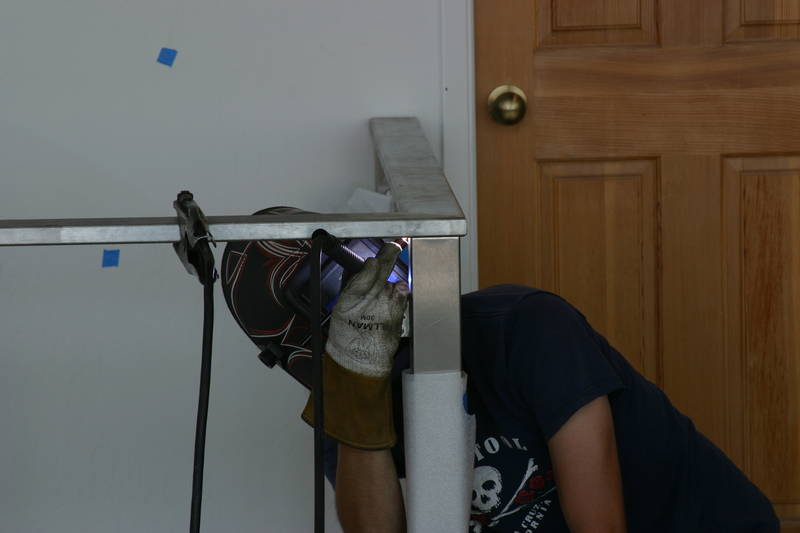 Welding the rail to the post. He's...